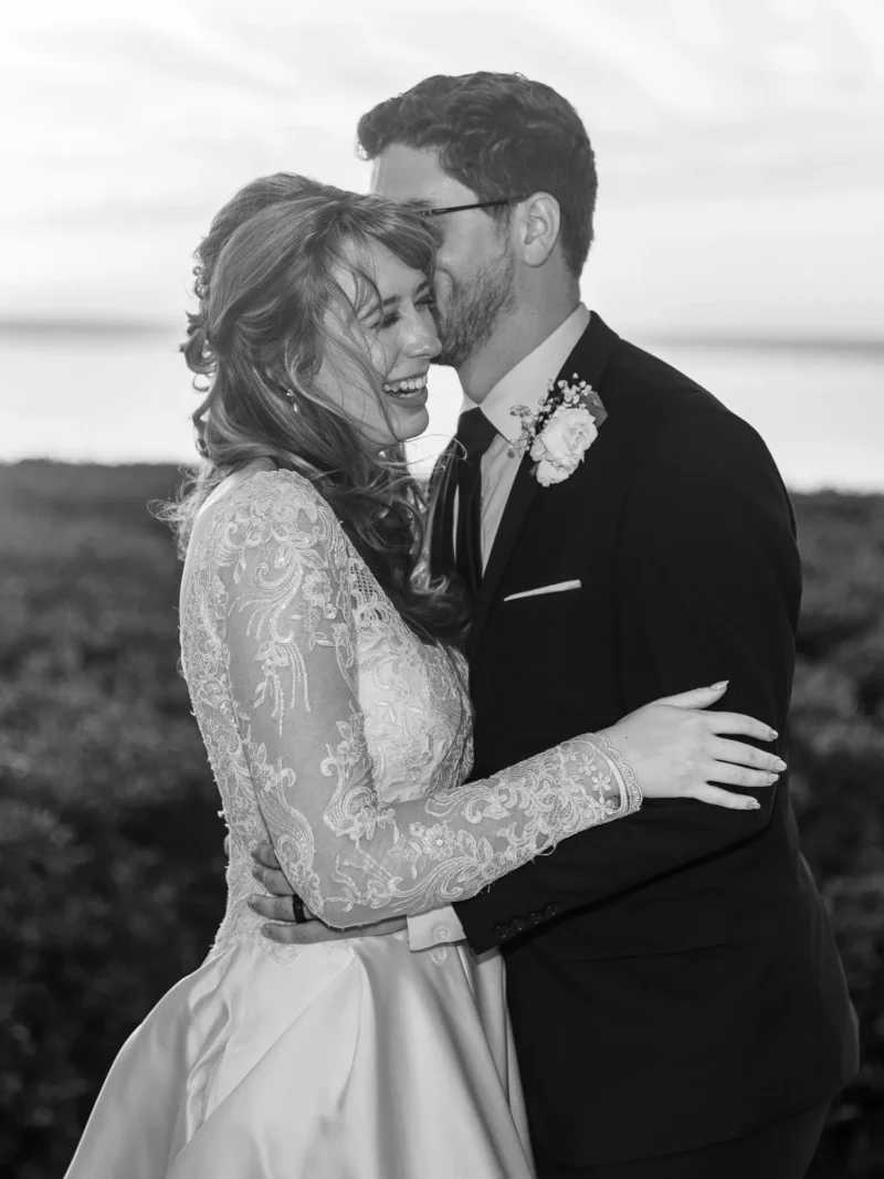 A couple embraces in a romantic moment at sunset, dressed elegantly for a special occasion with a serene beach backdrop. A couple embraces in a romantic moment at sunset, dressed elegantly for a special occasion with a serene beach backdrop.